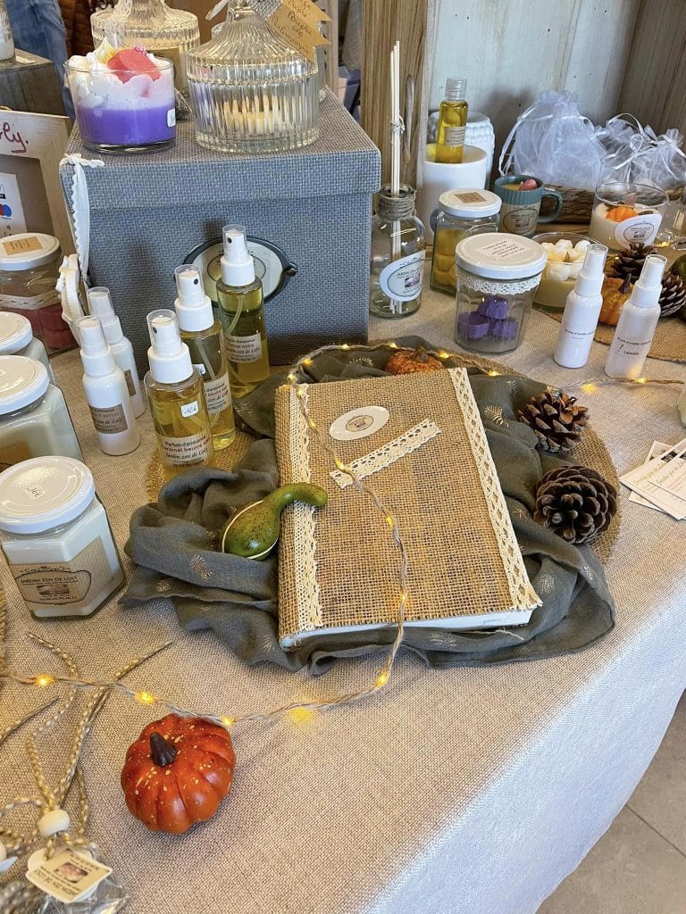 Ensemble de produits fabriqués par Loly (livre décoratif, bougies, diffuseurs) lors d'une exposition